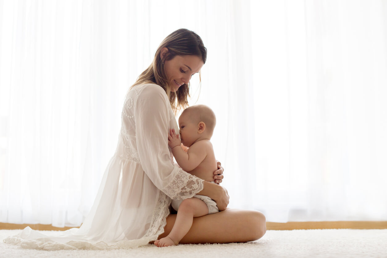 Une mère assise qui allaite son bébé.