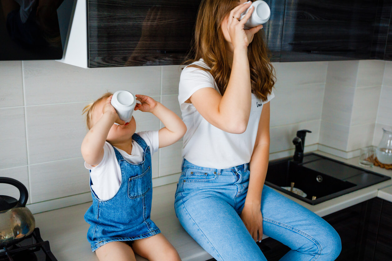 Une maman et sa fille qui boive dans un verre.