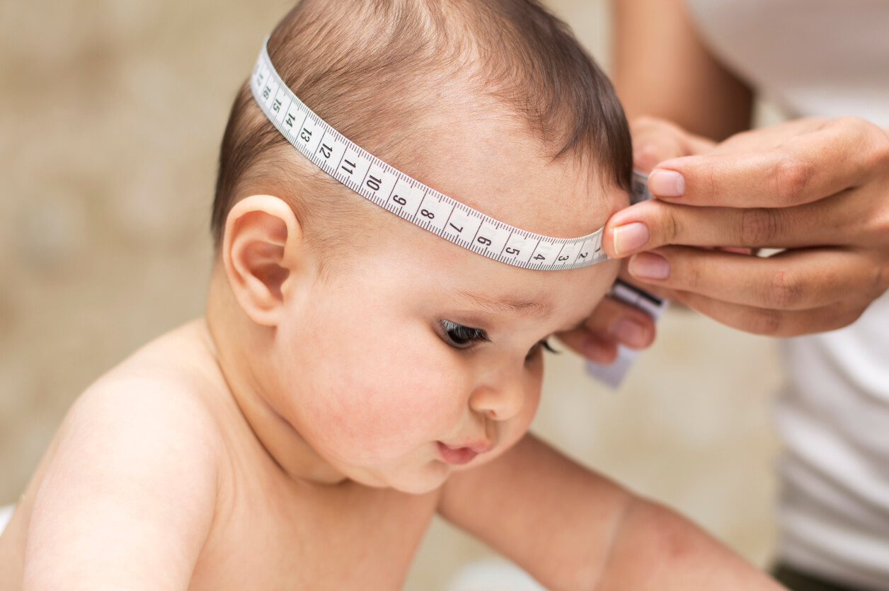 perimetro cefalico craneo medicion circunferencia bebe erguido cinta metrica mano pediatra enfermera bebe lactante tranquilo control salud