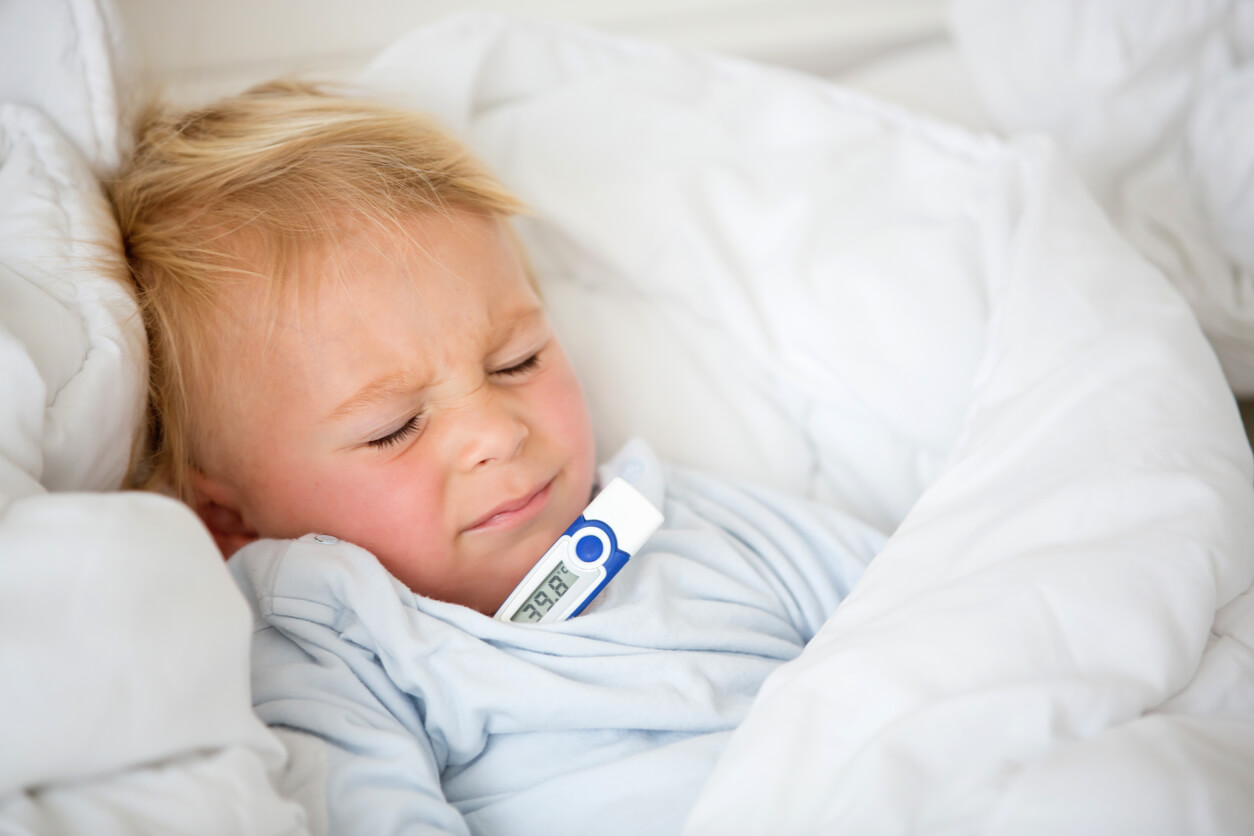 nino nene pequeno fiebre cansado en cama termometro temperatura alta rubicundo malestar general dolor