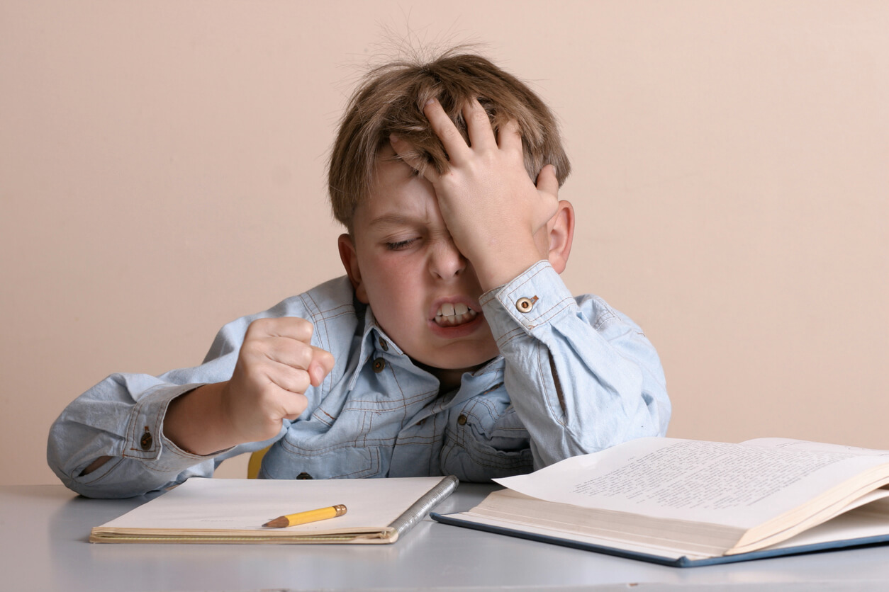 Et barn som er frustrert over skolearbeidet sitt.