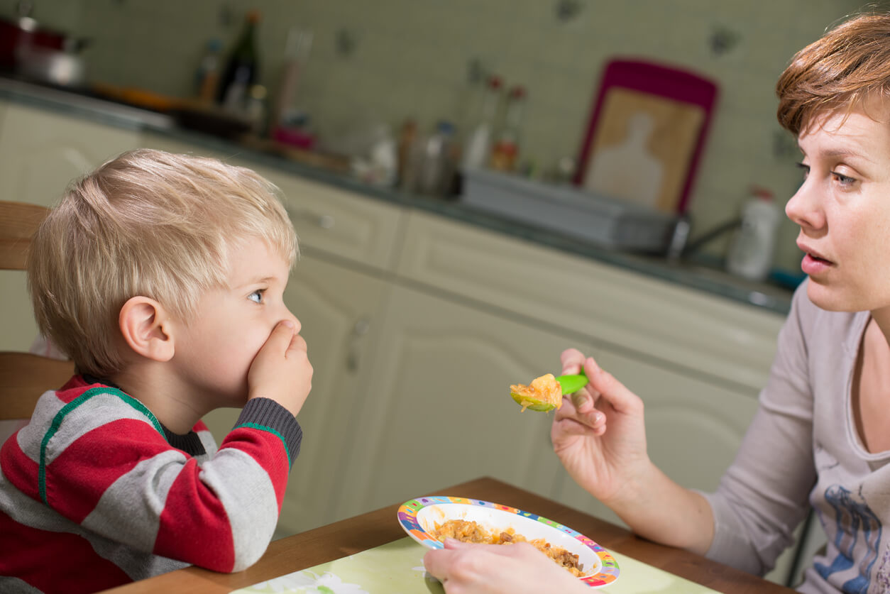 nino nene no quiere comer tapa boca mano mama madre cuchara plato comida rehusa inapetencia fisiologica