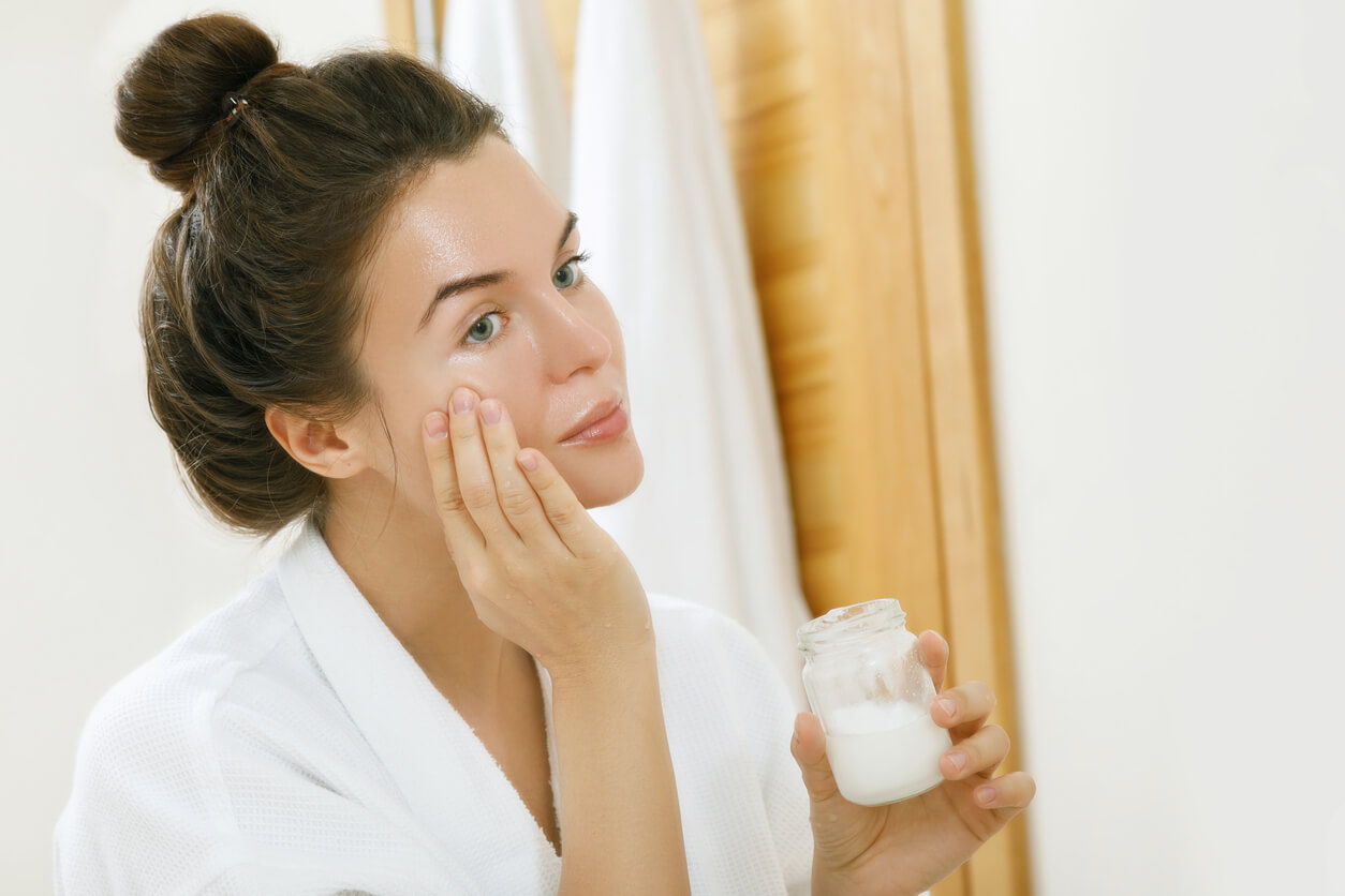 mujer aplica aceite coco cara hidratante cosmetico cuidado piel embarazo
