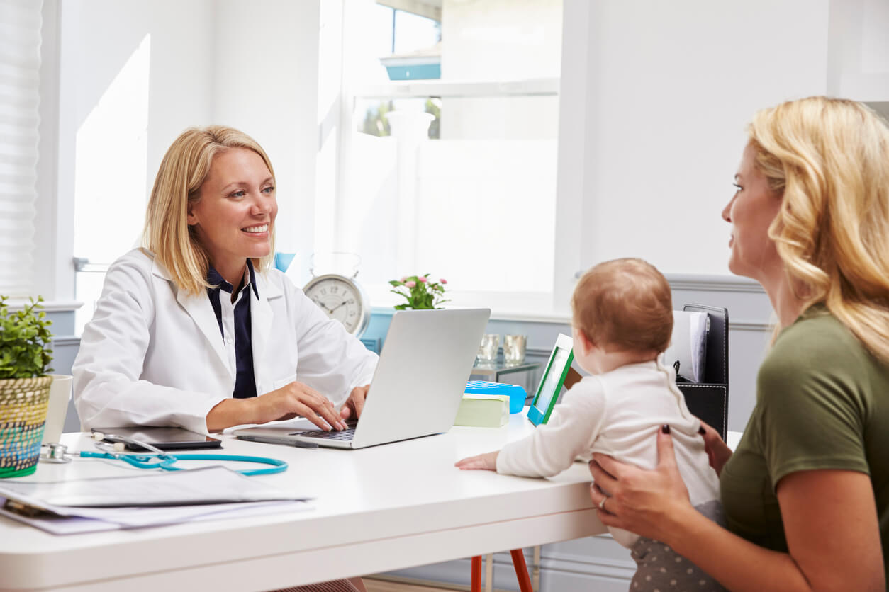 A mother and baby at an appointment with a pediatrician.