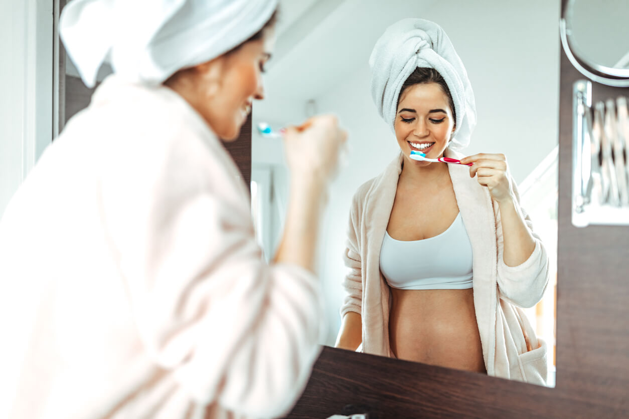 Une femme enceinte qui se brosse les dents. 