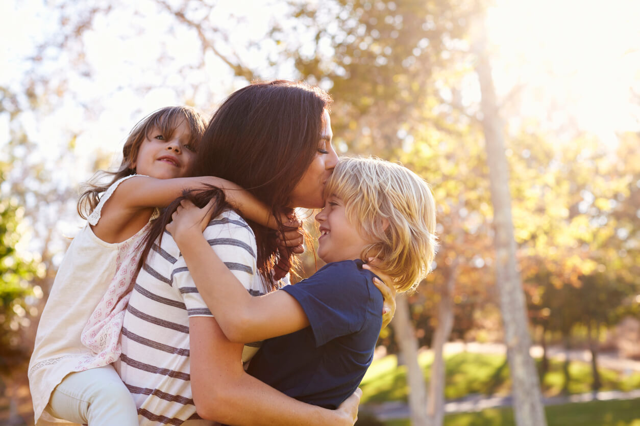 amor madre hijos beso parque aire libre upa