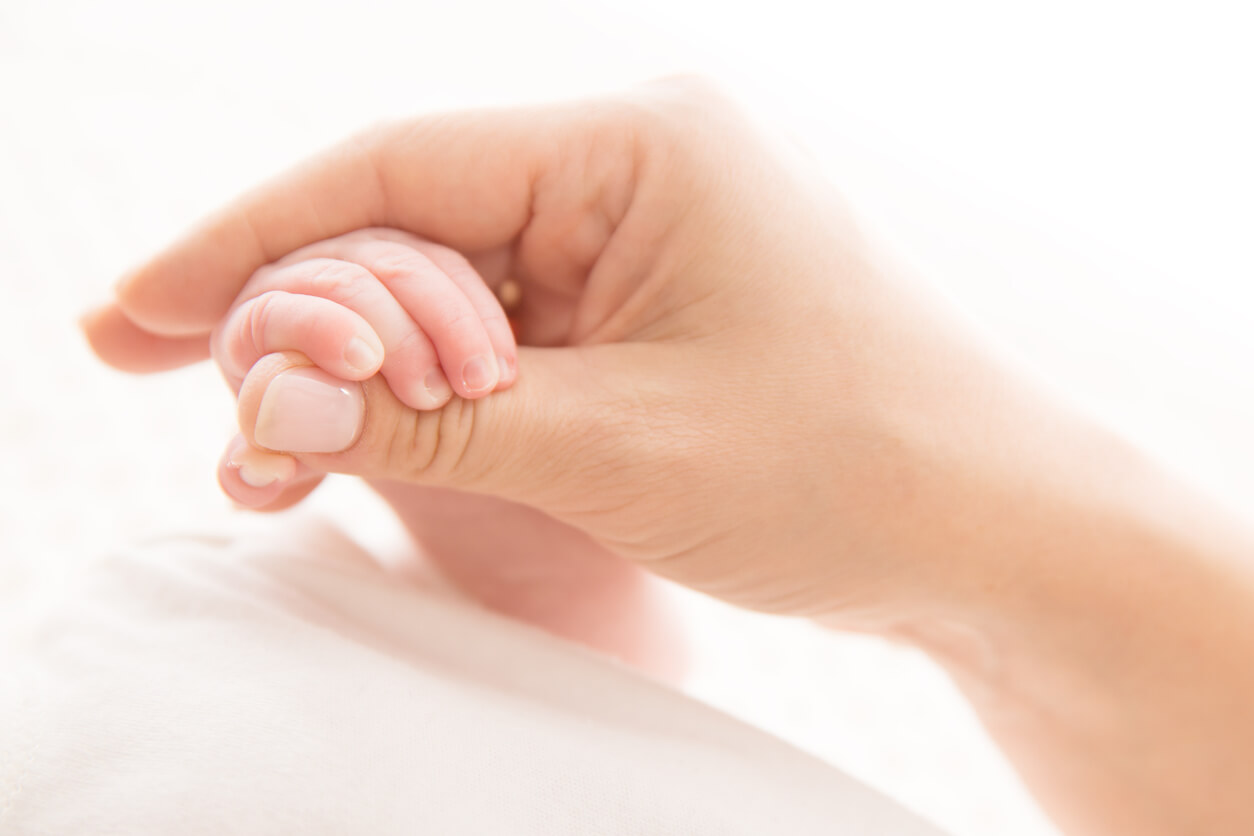 reflejo primitivo prension palmar bebe recien nacido neonato mano madre adulto agarra