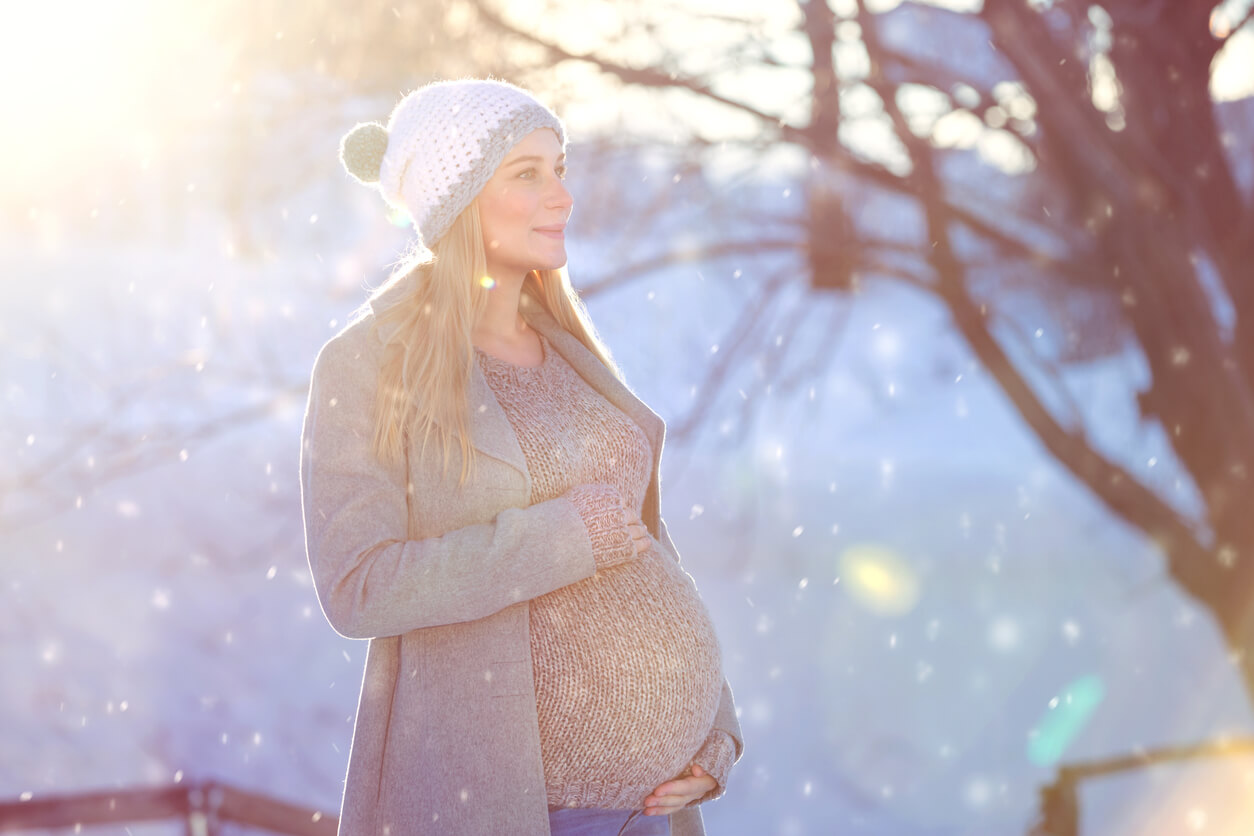 A pregnant woman in the snow.