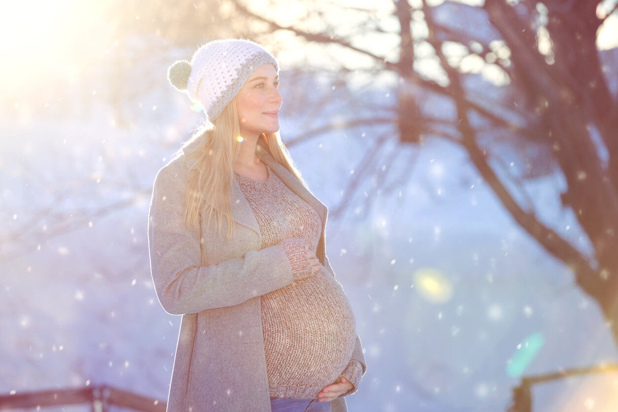 invierno nieve mujer embarazada vientre gorro lana abrigo frio feliz