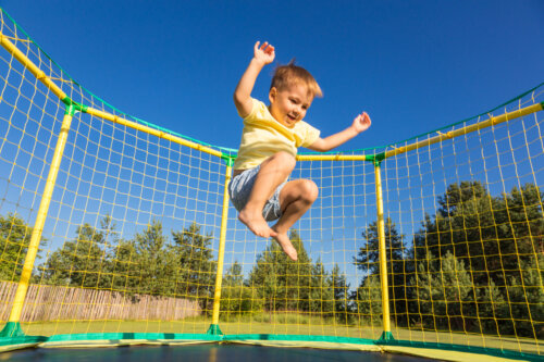 nino nene salta cama elastica actividad fisica deporte hiperactivo nervioso energico feliz gasto energia dia tarde verano aire libre