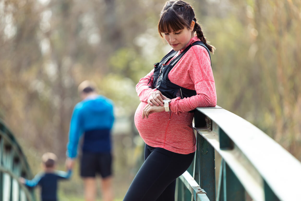 Una Joven Embarazada En Ropa Deportiva Medita Sentada Con El