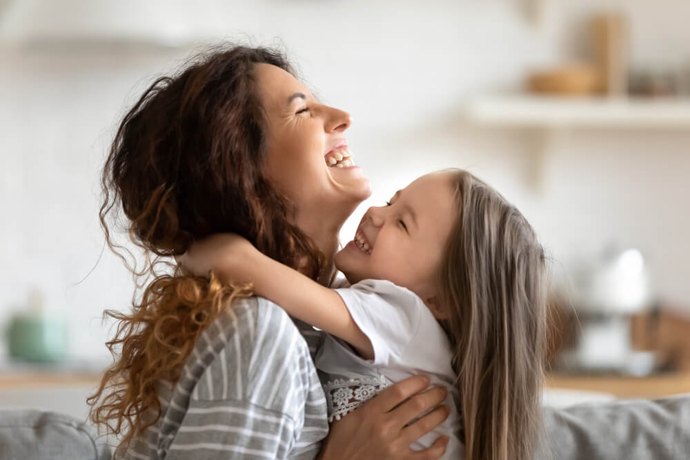 Une mère et une fille qui échangent un câlin.