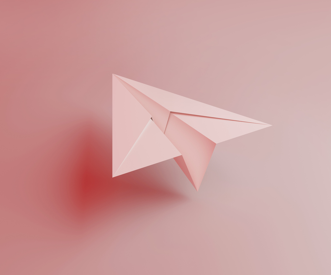 Avion en papier rose.