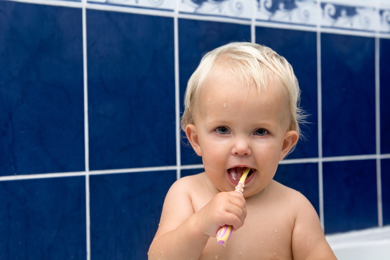 Bebê na banheira escovando os dentes.