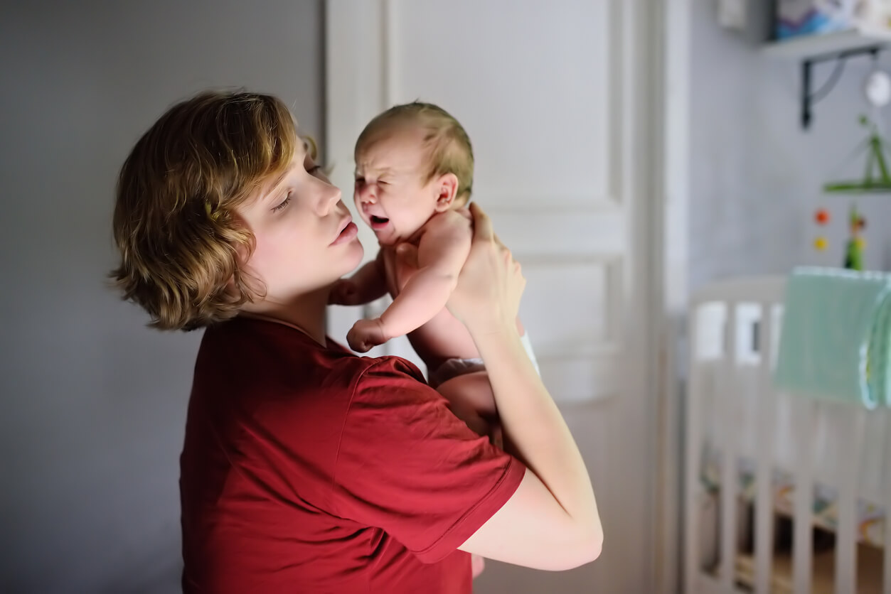 A mother picking up her newborn.