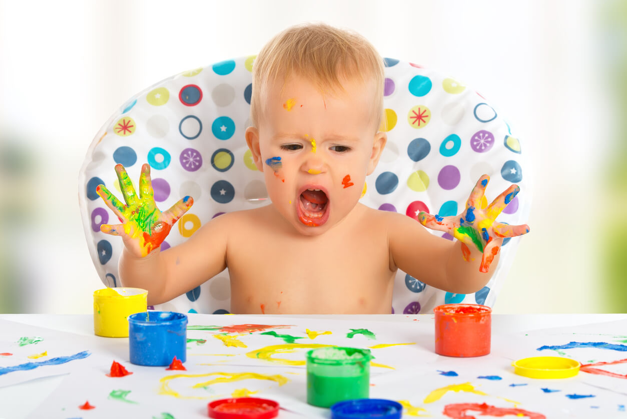 Un enfant qui peint avec ses doigts.