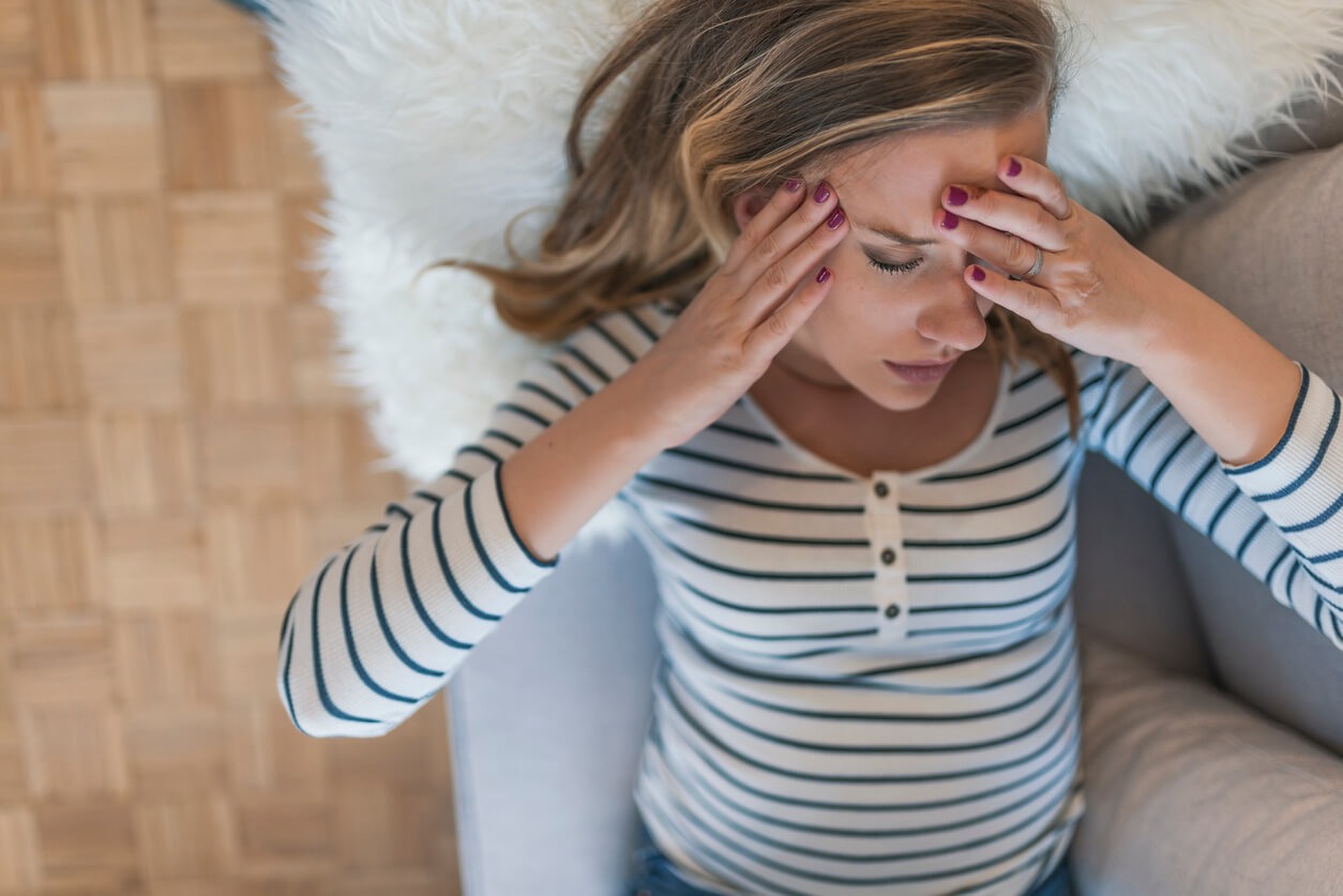 femme enceinte allongée sur le canapé maux de tête inconfort migraine