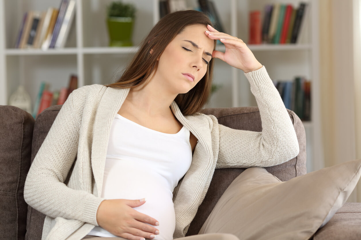 Une femme enceinte assise avec des vertiges.