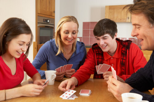 familia juega juego mesa cartas momento compartido ocio tiempo libre