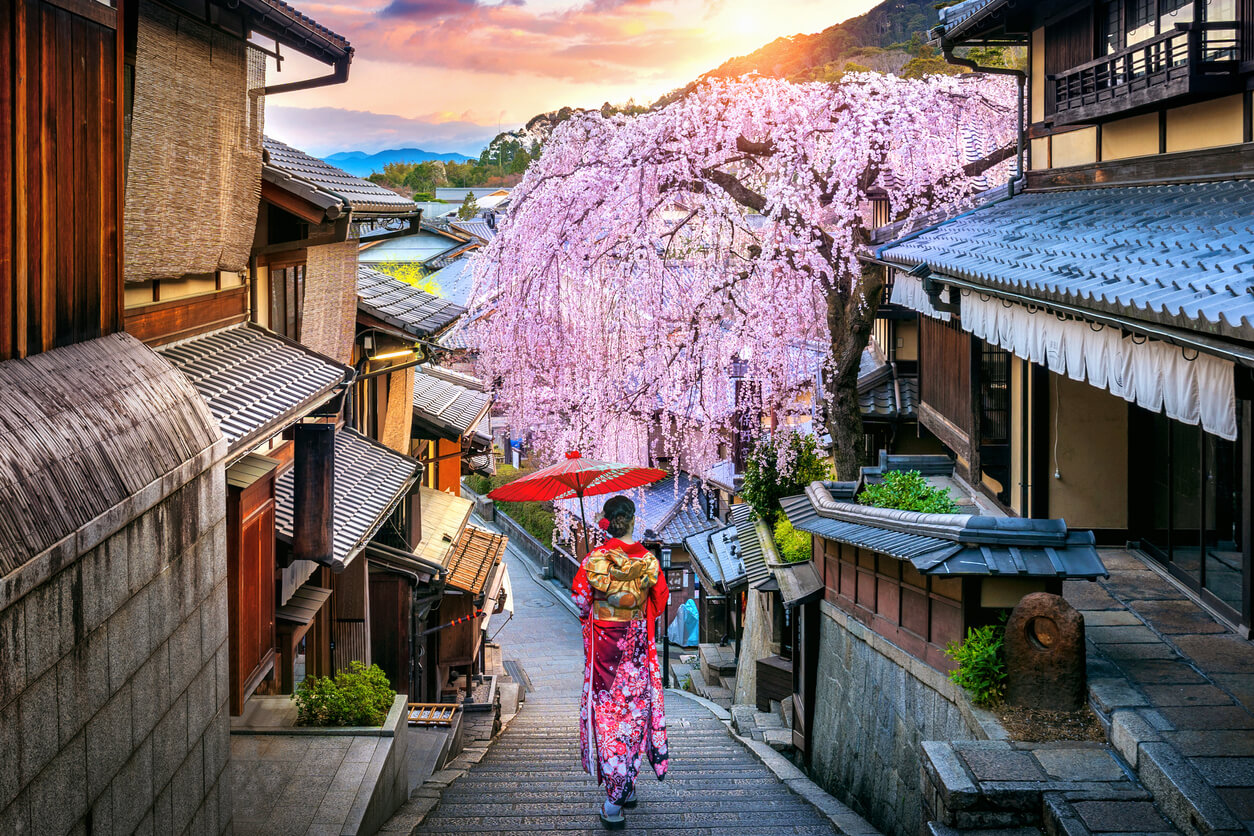 Nainen kävelee pitkin kaunista polkua japanilaisessa kaupungissa.
