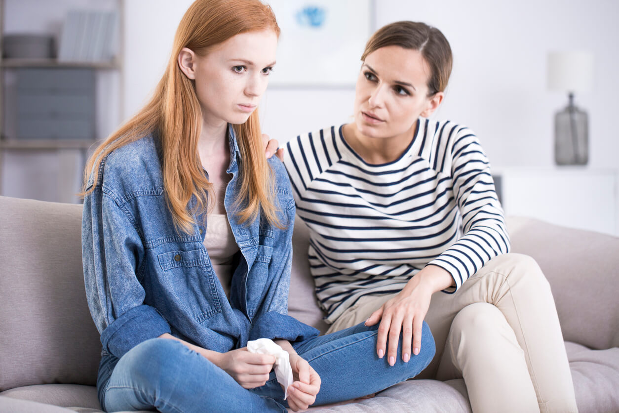 mère réconforte sa fille sur le canapé