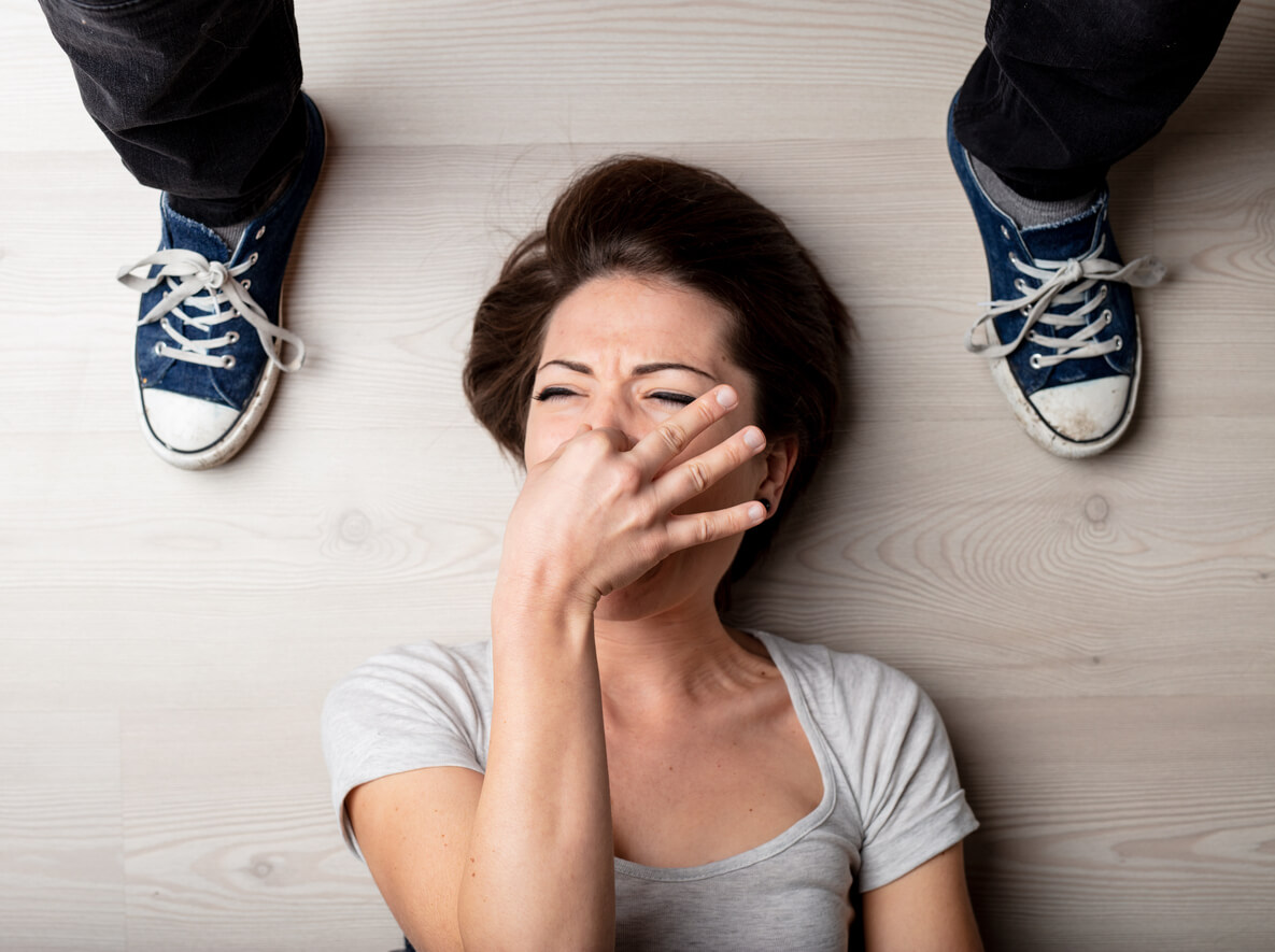 Une femme qui se bouche le nez à côté de chaussures.