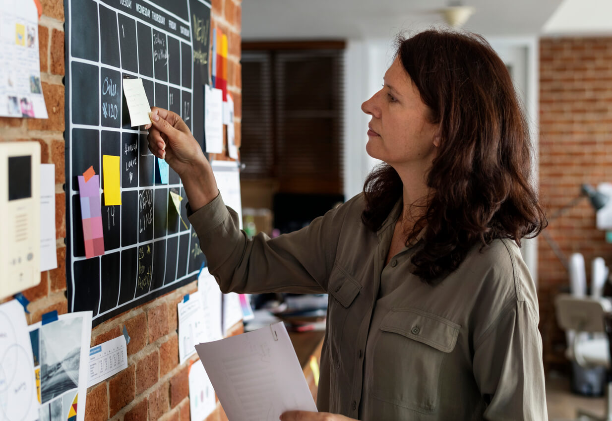 mujer madre organiza tareas calendario pegatinas recordatorios