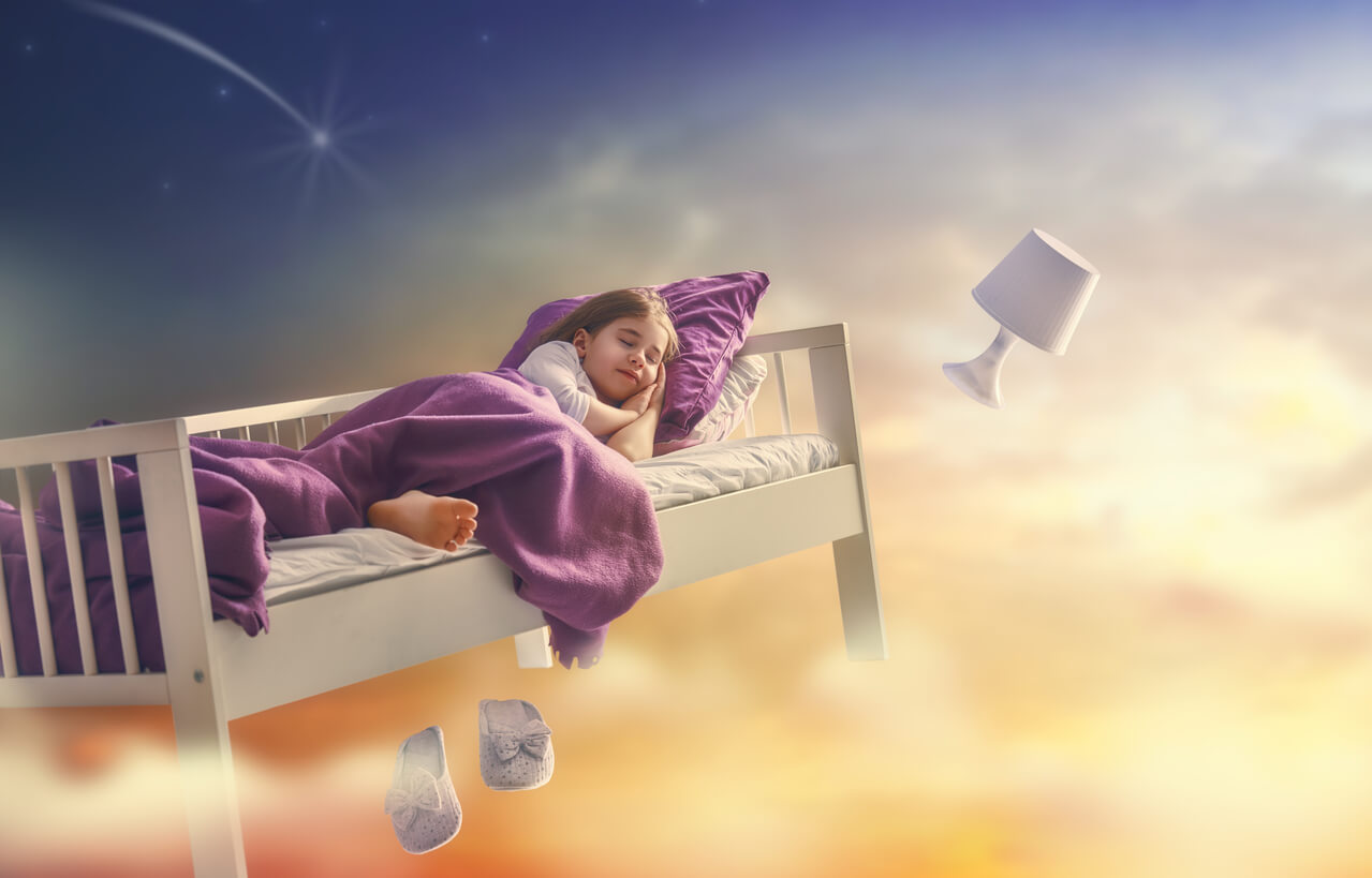 Une jeune fille qui dort dans son lit qui vole dans le ciel.