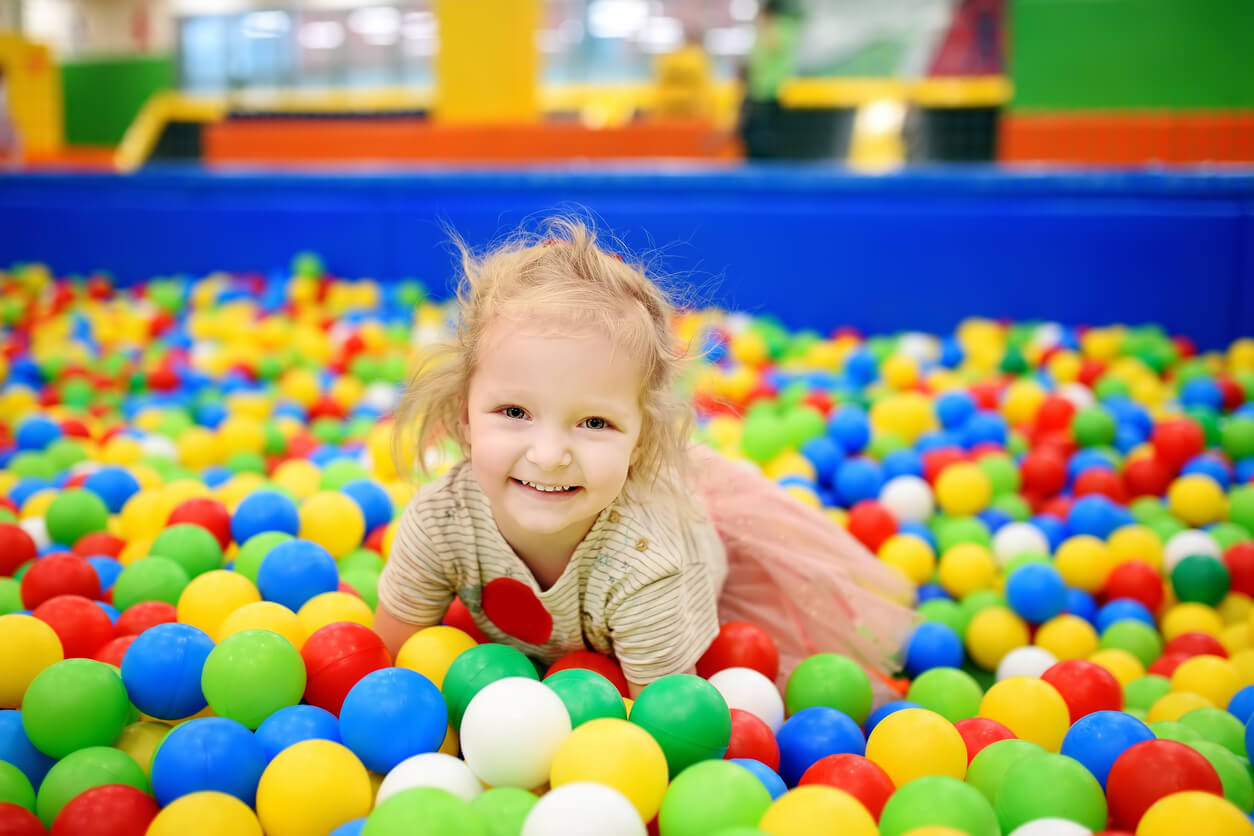 Une jeune fille qui joue dans une piscine à balles.