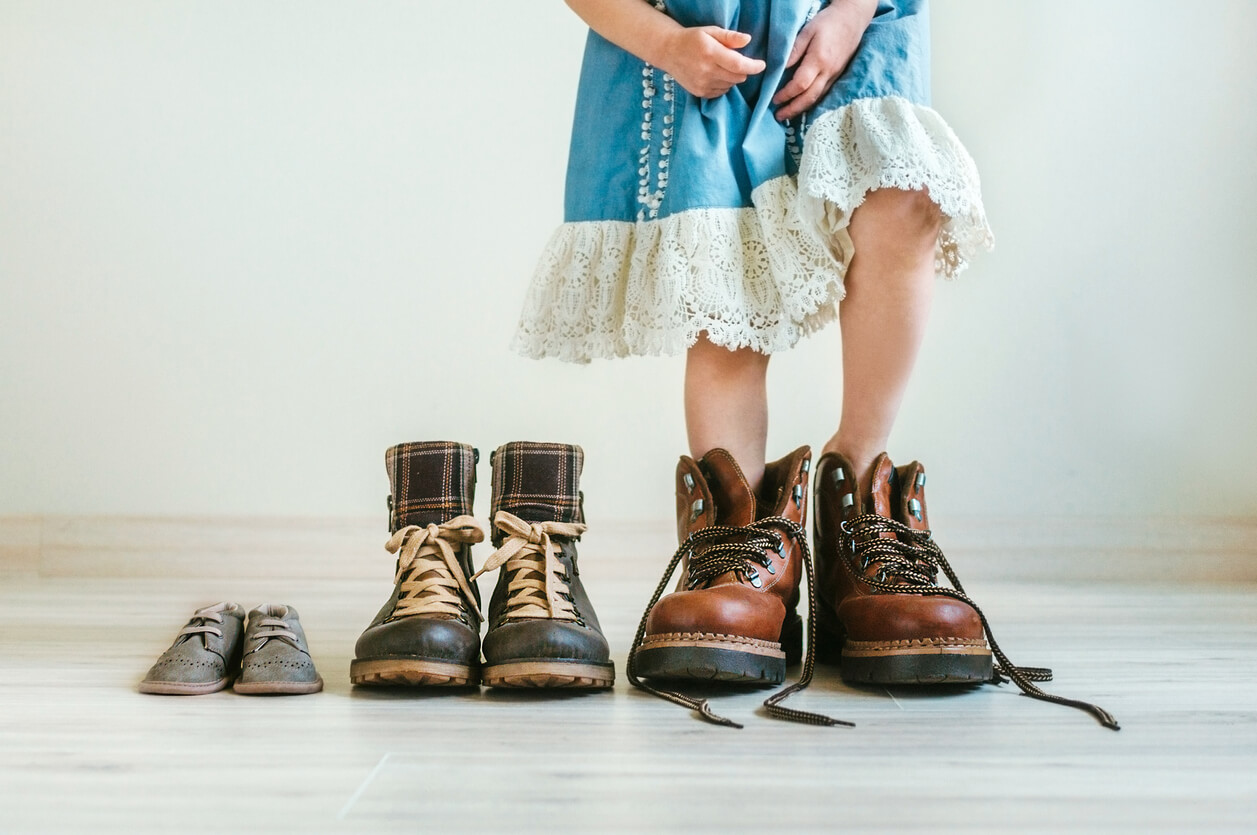 Une jeune fille qui met les chaussures de son père. 