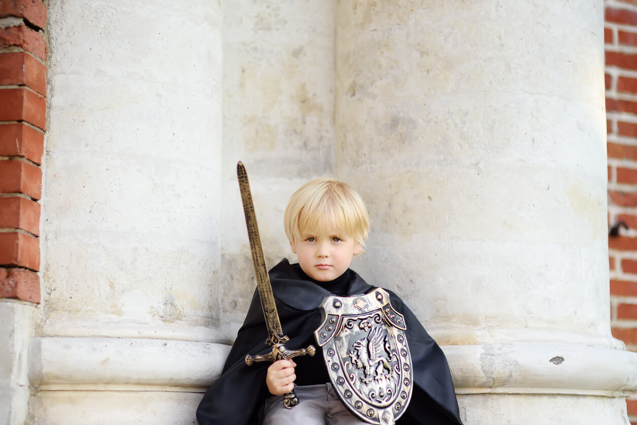 Ett litet barn utklädd till en riddare.