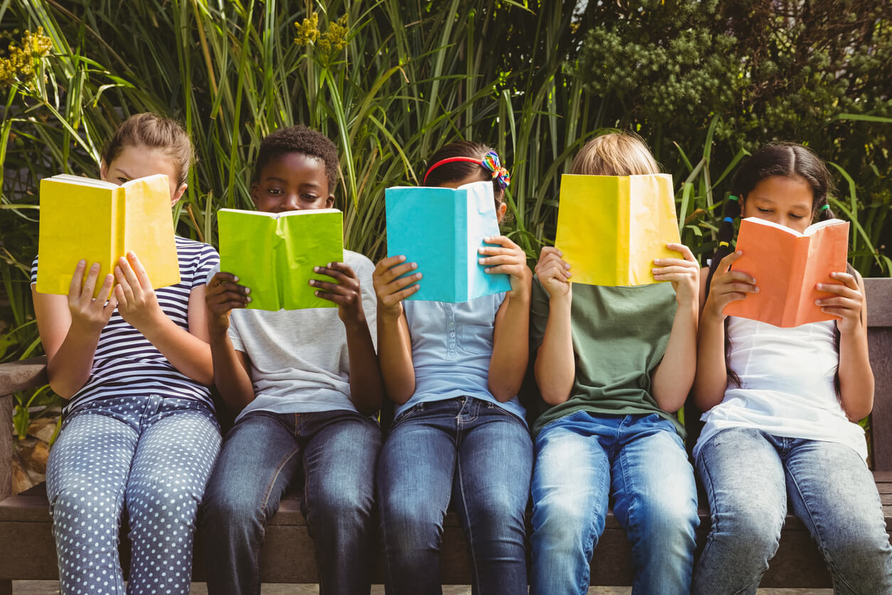 ninos sentados leyendo leen parque libros colores lectura compartida