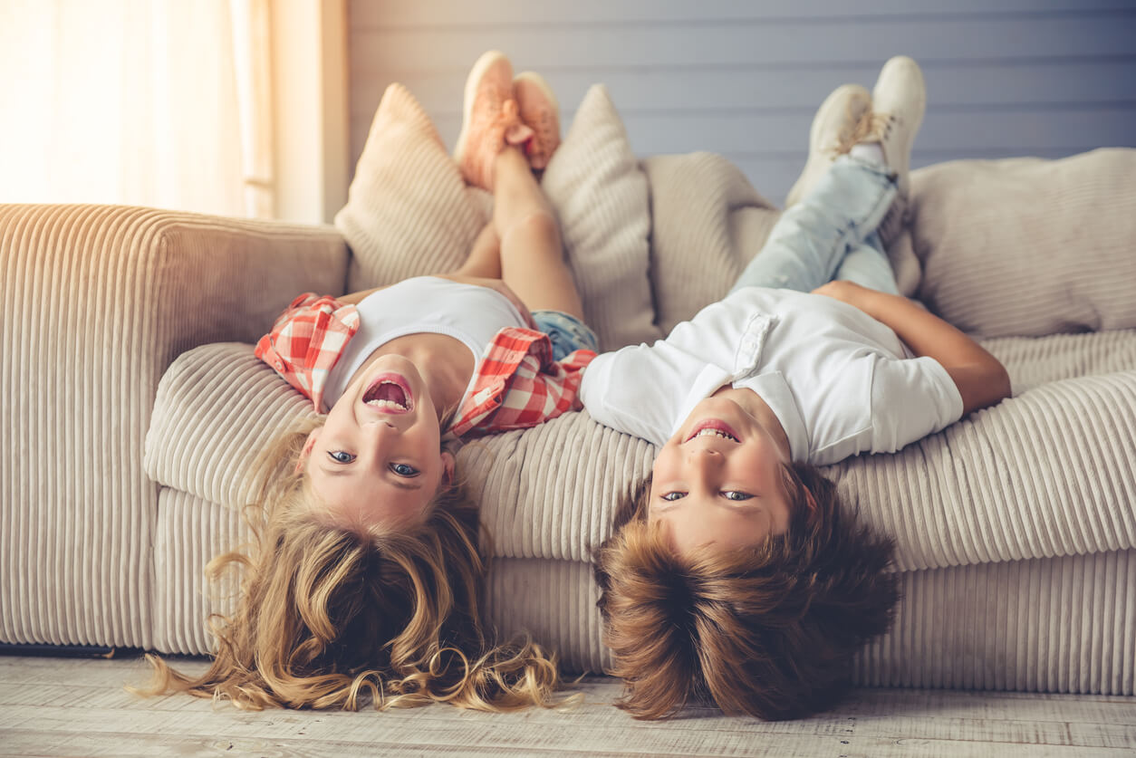Deux enfants allongés sur un canapé.