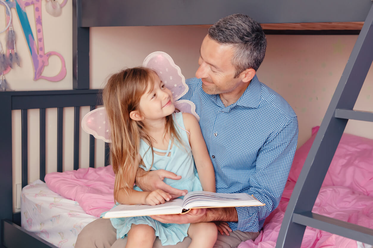 A father reading a fairytale to his daughter.