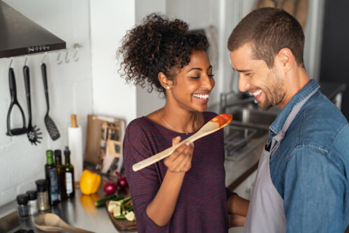 pareja joven feliz cocinando juntos cena cuchara comida preconcepcion fertilidad