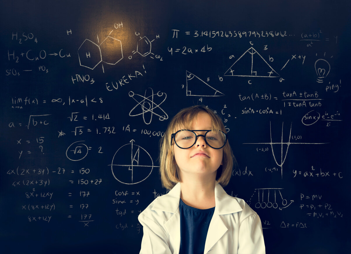 A young girl with high intellectual abilities standing in front of a chalkboard full of mathematical equations.