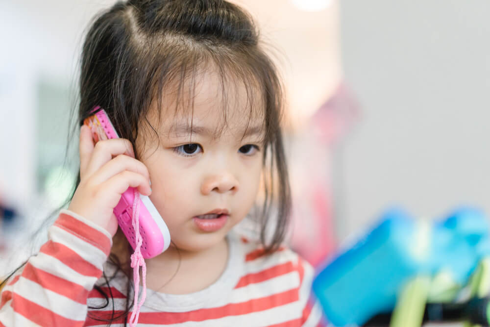 petite fille qui parle seule au téléphone