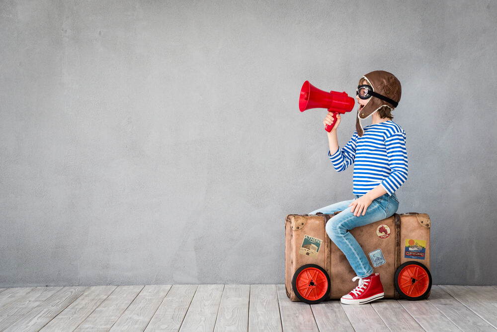 Un garçon parle seul en jouant avec une voiture.