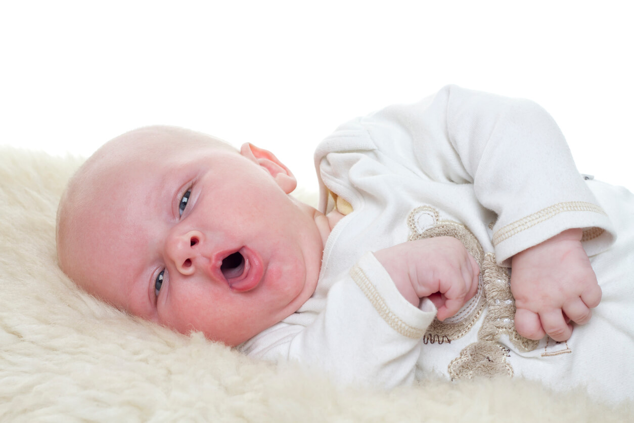 Un bébé qui tousse allongé sur le côté.