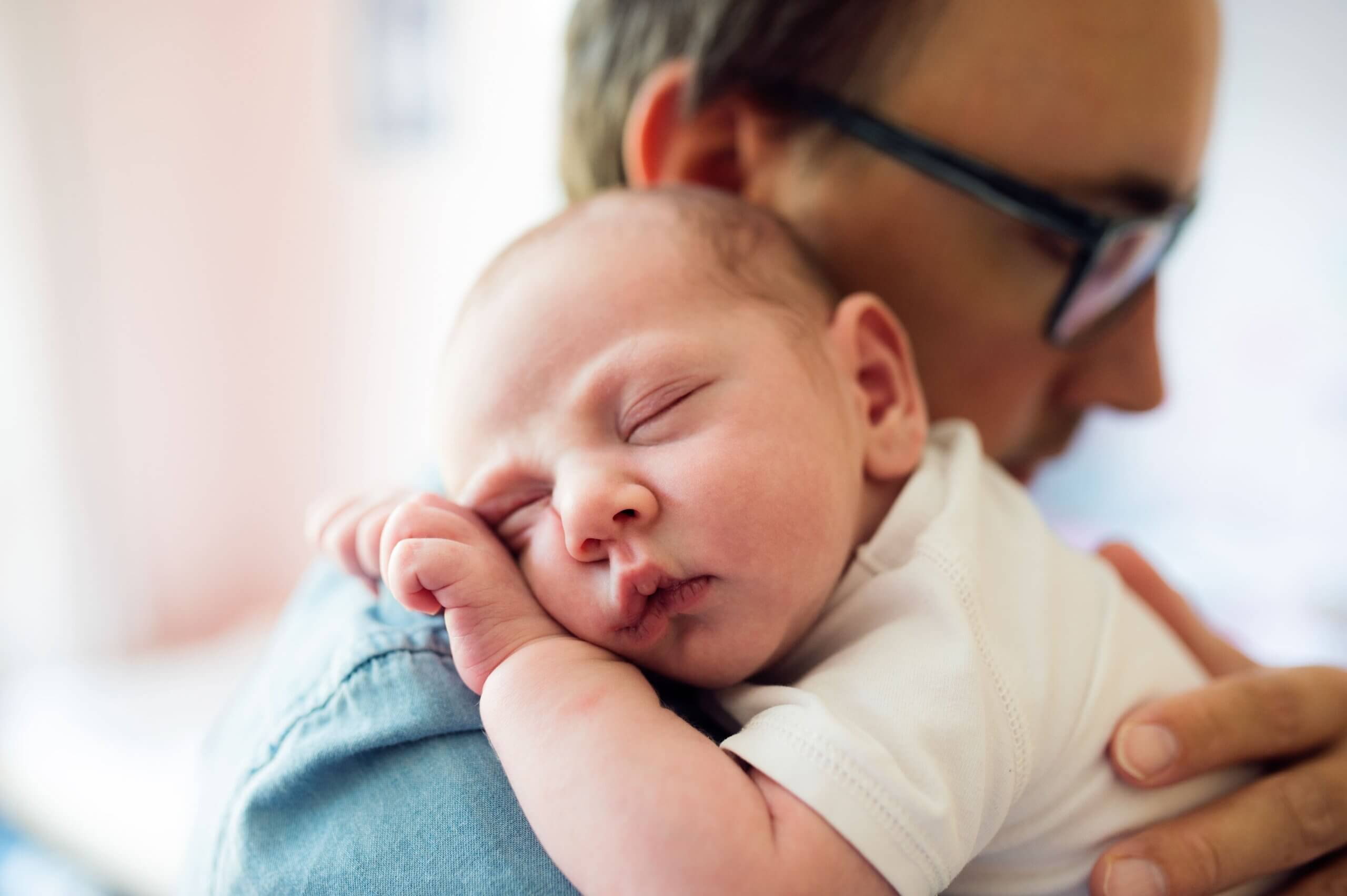 Un père avec son bébé dans les bras.