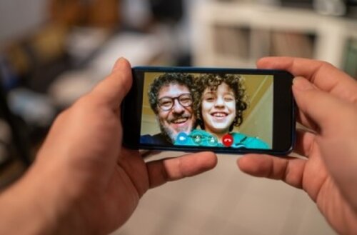 Papá e hijo comunicándose por videollamada