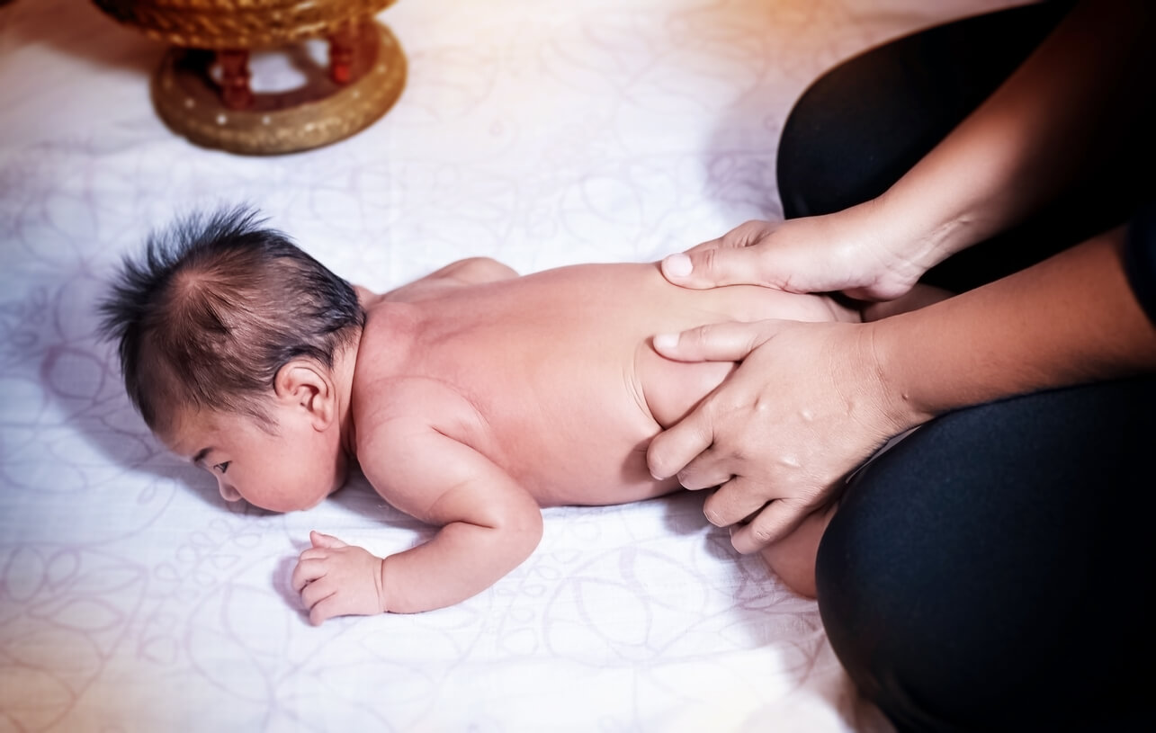 Massage lombaire d'un bébé. 