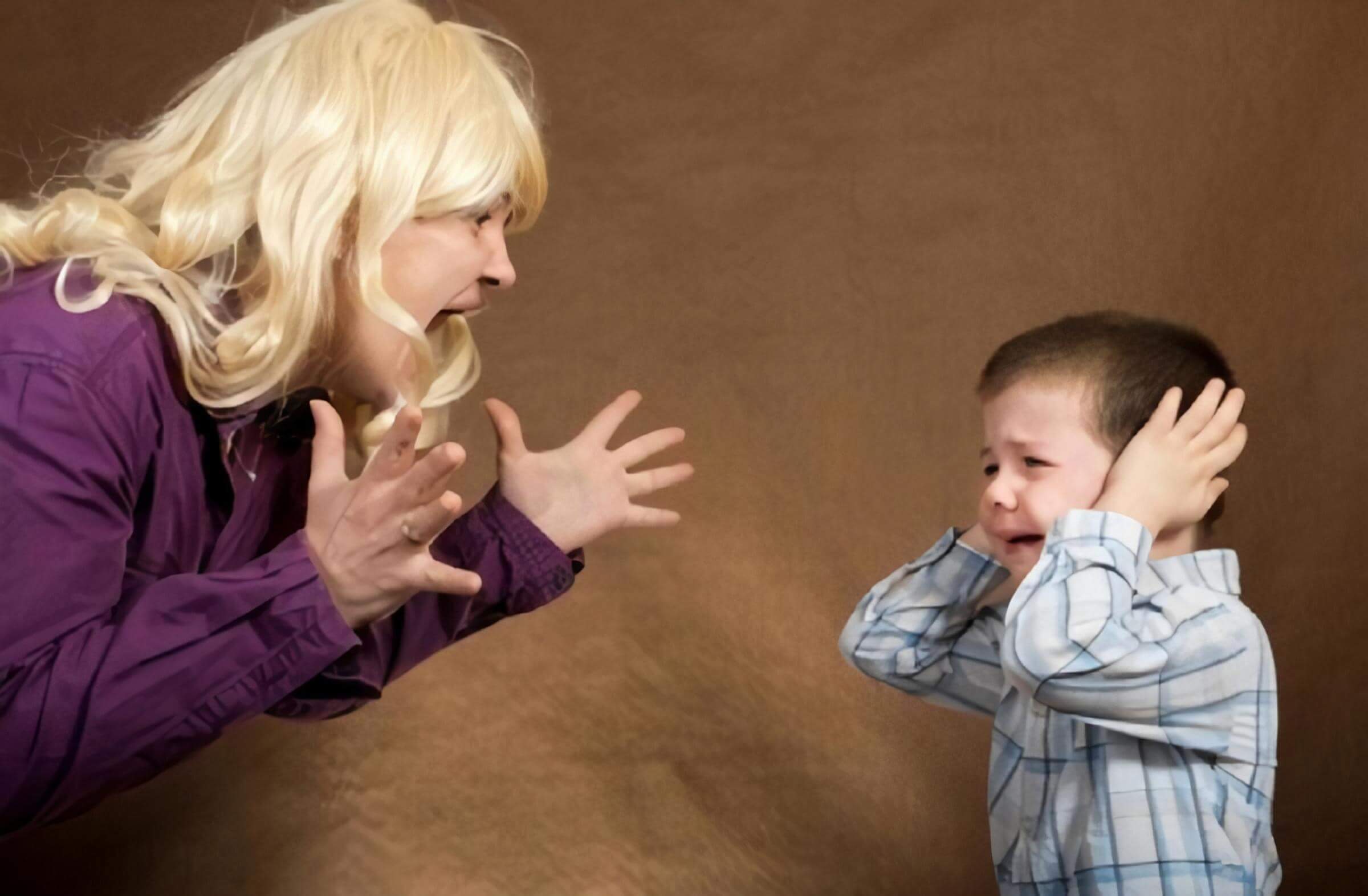A mother screaming at her toddler son as he cries and covers his ears.