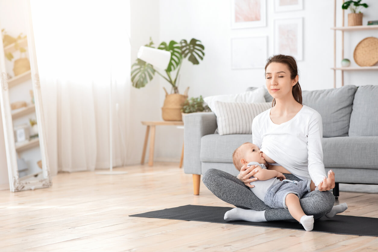 Une maman qui pratique le yoga en allaitant son bébé.