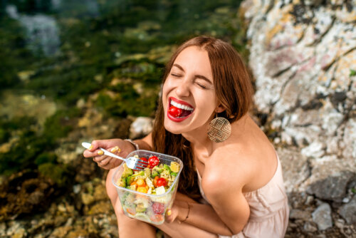 chica joven come ensalada vegetales feliz saldable