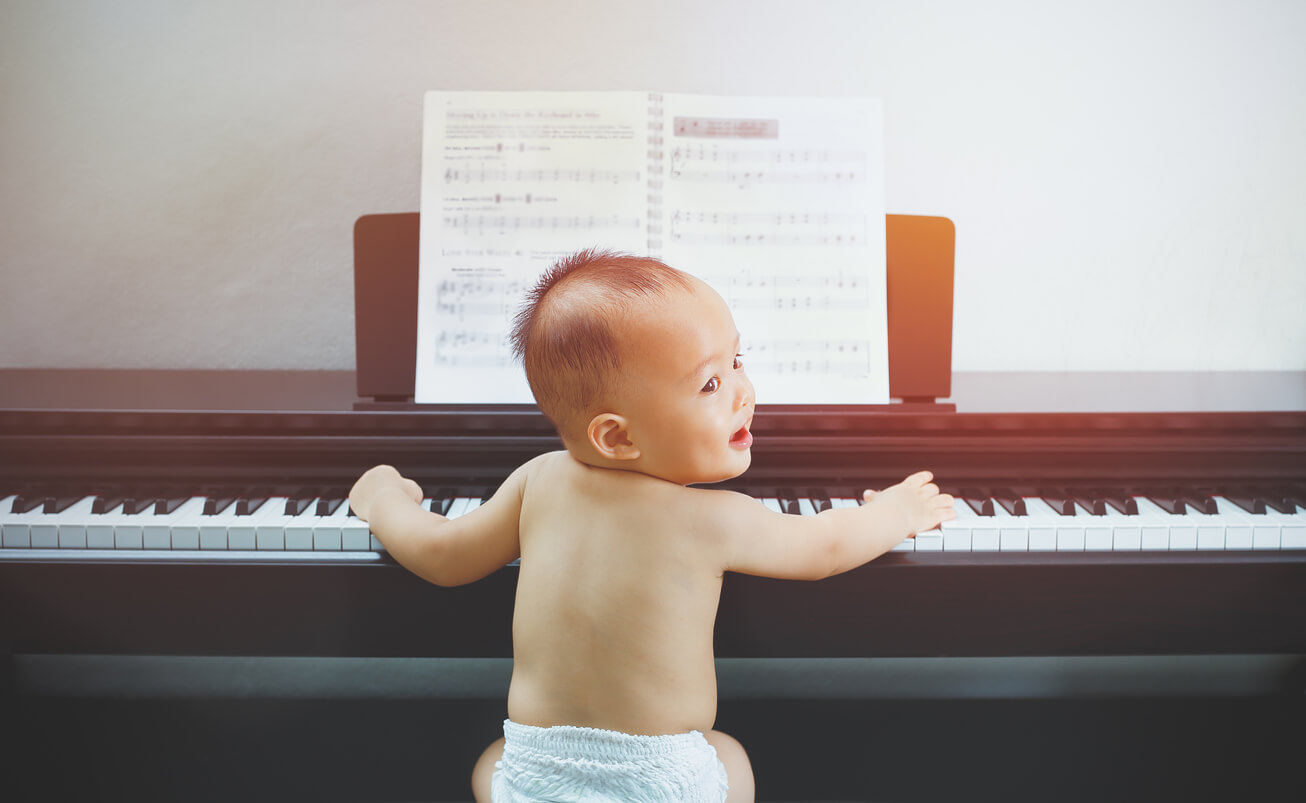 concetto di intelligenza dotato bambino dotato in pannolini seduto sulla panchina del pianista
