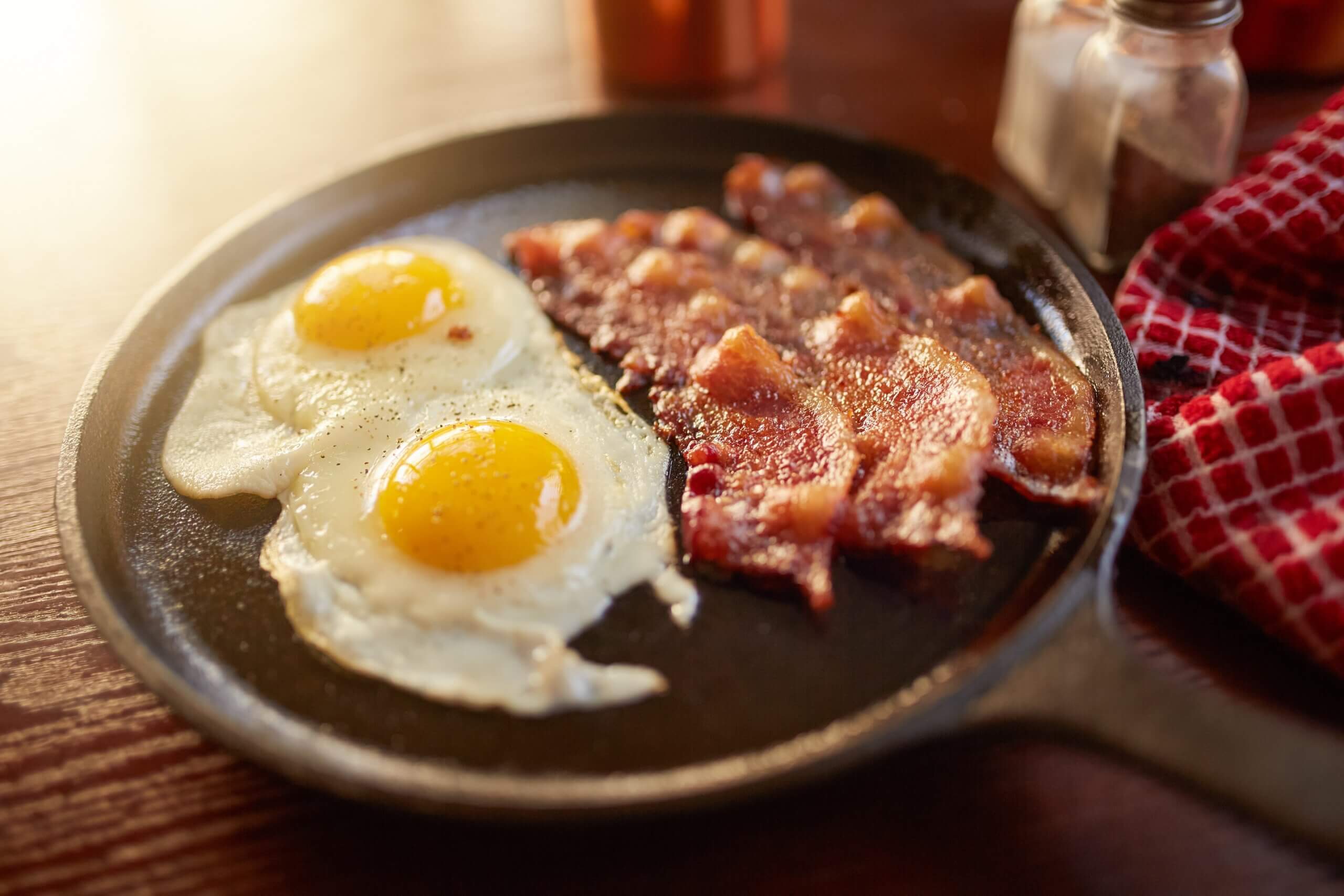 A skillet with bacon and eggs.
