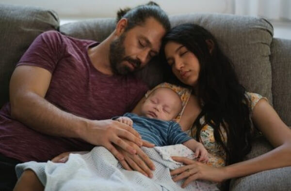 Padres y bebé durmiendo la siesta