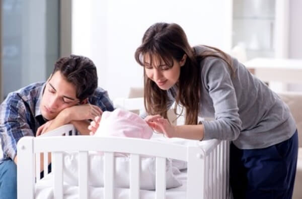 Nouveaux parents à côté de leur bébé.
