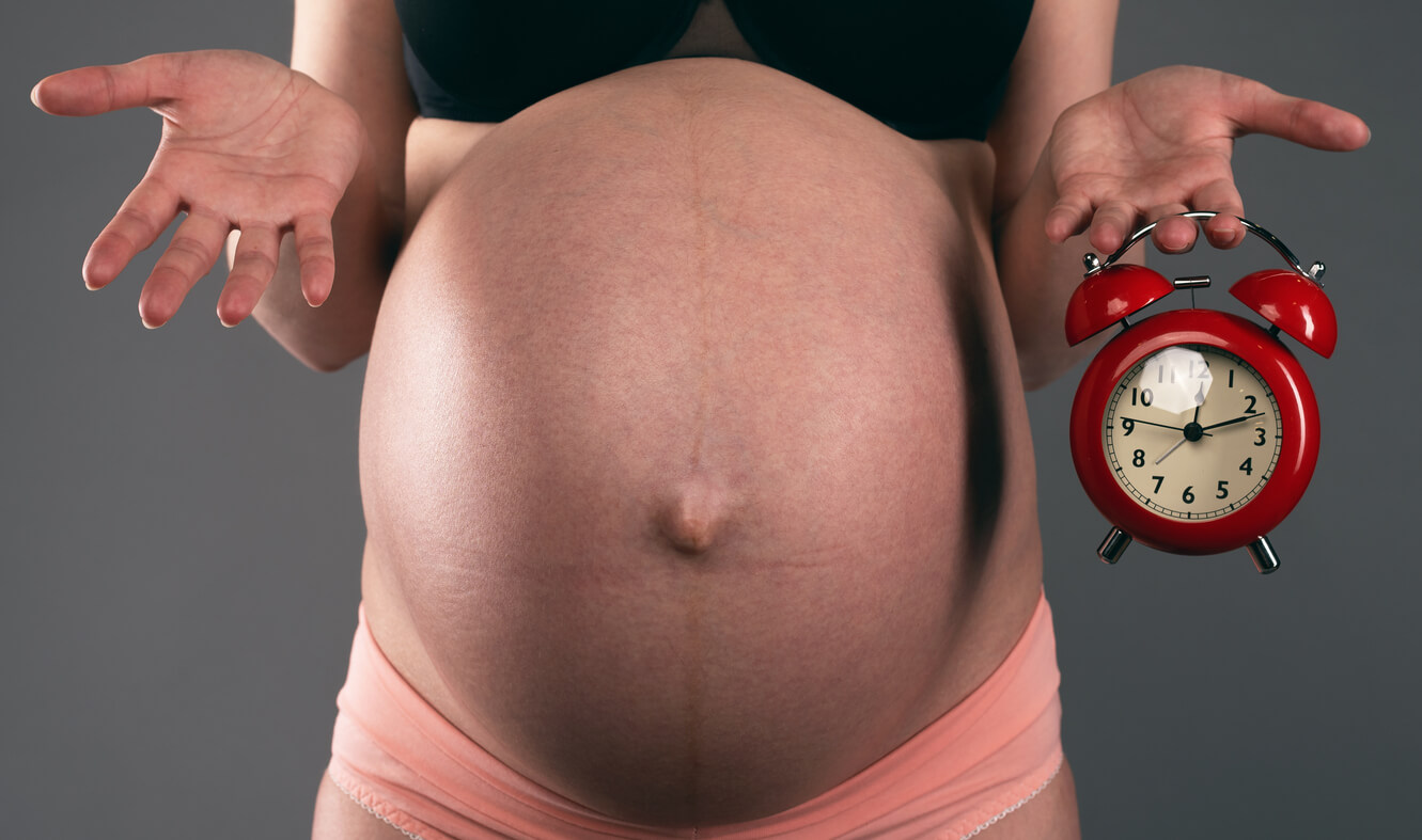 femme enceinte ventre horloge doute expression mains